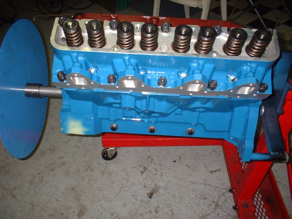 Blue engine block with valve springs on a red stand