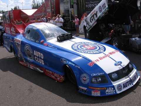 1998 GMC Sierra 1500 - A drag racing car with extensive sponsorship branding is parked on asphalt.
