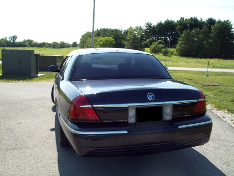 1999 Mercury Grand Marquis - Rear view of a dark 1999 Mercury Grand Marquis parked on an asphalt surface.