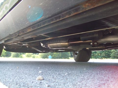 1999 Mercury Grand Marquis - The underside of a vehicle reveals its exhaust system, including a prominent Magnaflow catalytic converter.