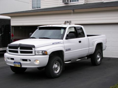 1990 Chevrolet Suburban - This white pickup truck has a distinctive grille and fender badging that does not match the claimed 1990 Chevrolet Suburban.