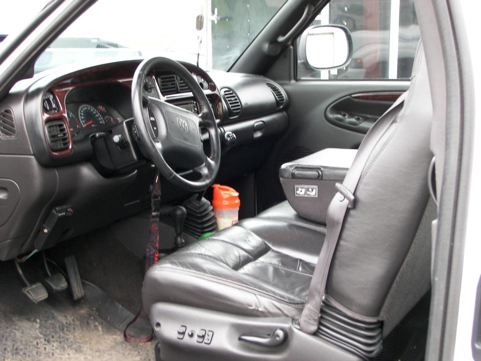 Interior view of a truck's dashboard and leather seats, showing a gear shifter and center console