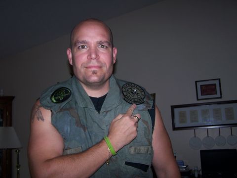 1986 Ford Bronco - Man wearing a vest with patches, one of which says ALPHA BLACK BRAVO ONE TASK FORCE.