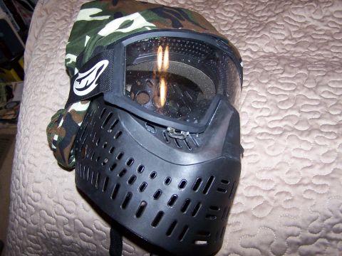 1986 Ford Bronco - A black paintball mask with camouflage accents is shown up close on a textured background.