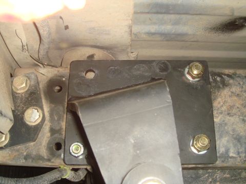 1992 Ford Bronco - Close-up of an aftermarket suspension part attached to a vehicle's frame, with visible bolts and metal components.