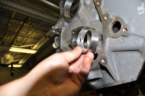 1996 Ford Bronco - A mechanic installs a bearing into an engine block, likely during a repair or rebuild process.