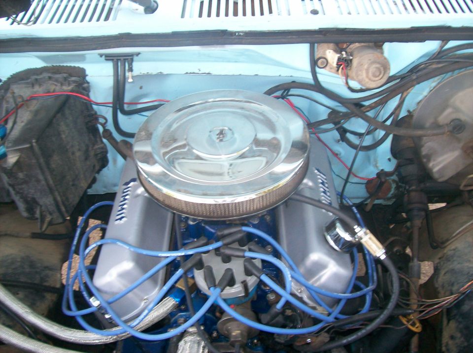 Engine bay with chrome air cleaner, silver valve covers, and blue spark plug wires