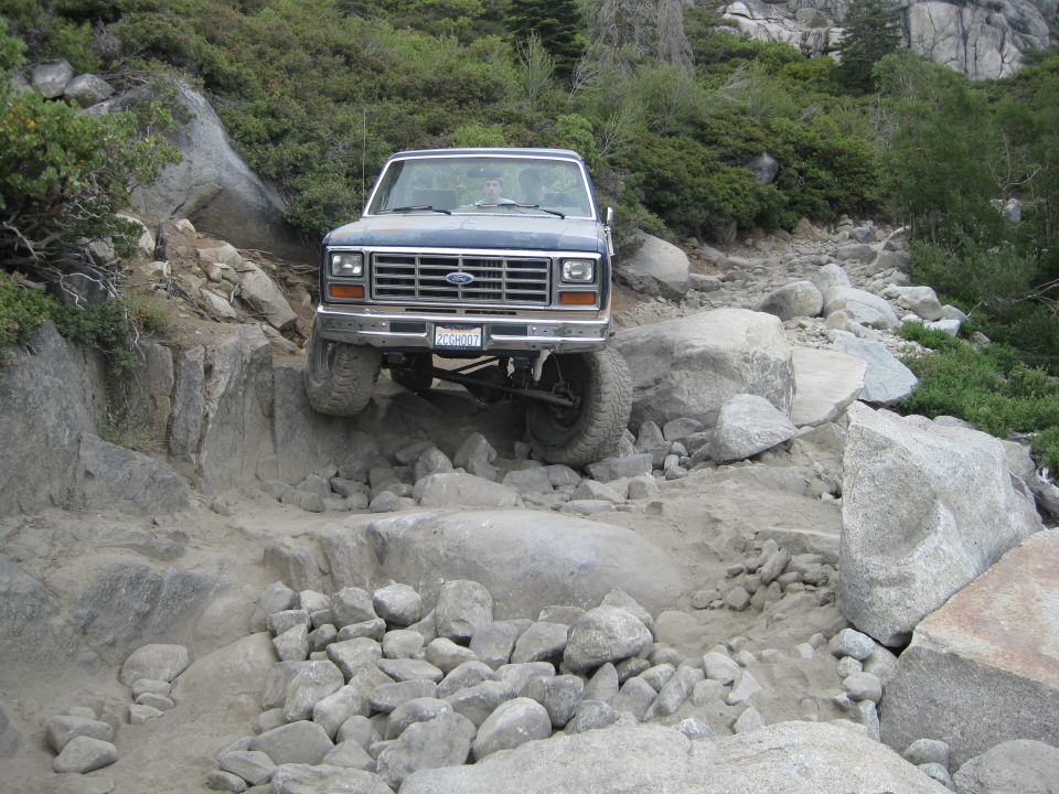 1986 Ford Bronco navigating a difficult rocky trail, front view