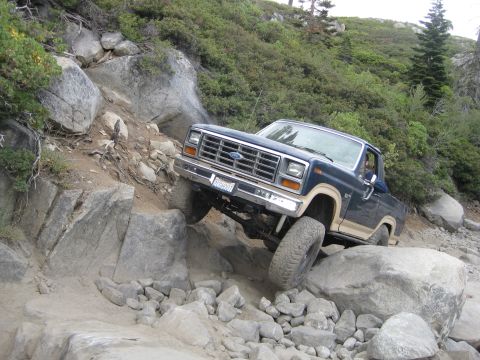 1986 Ford Bronco - This Ford F-Series truck is shown off-roading on a steep, rocky incline.