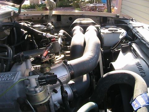 1985 Ford Bronco - Engine bay of a 1985 Ford Bronco, showing the air intake system and various hoses.