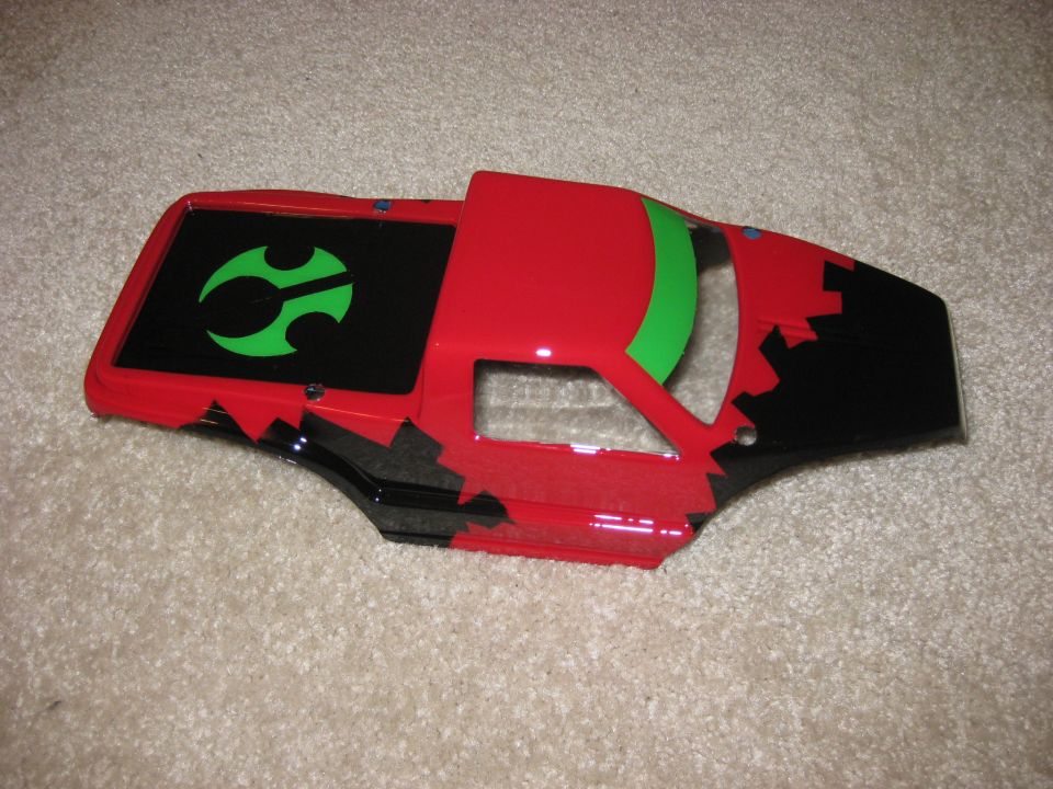 Red and black RC car body with green logo on the bed