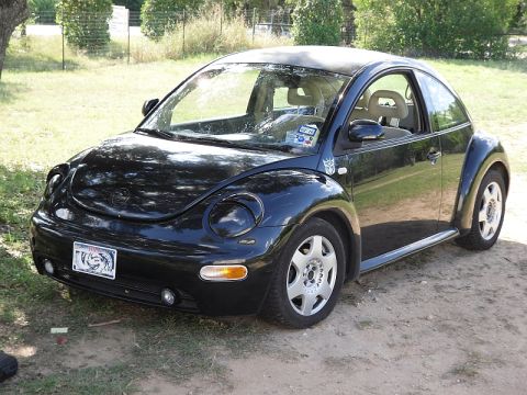1999 Volkswagen Beetle - This 1999 Volkswagen Beetle is seen from a three-quarter front view, parked on a dirt lot.