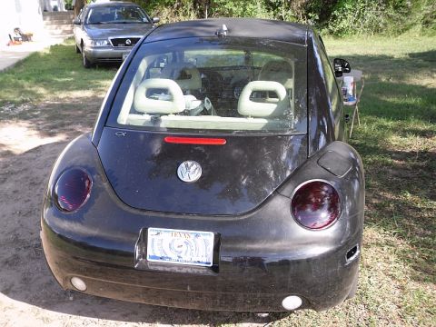 1999 Volkswagen Beetle - The rear view of a black Volkswagen Beetle shows its distinctive taillights and a Texas license plate.