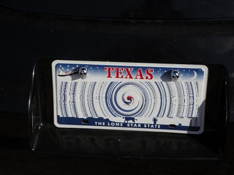 1999 Volkswagen Beetle - A Texas license plate features a hurricane graphic and skull-shaped bolt covers.