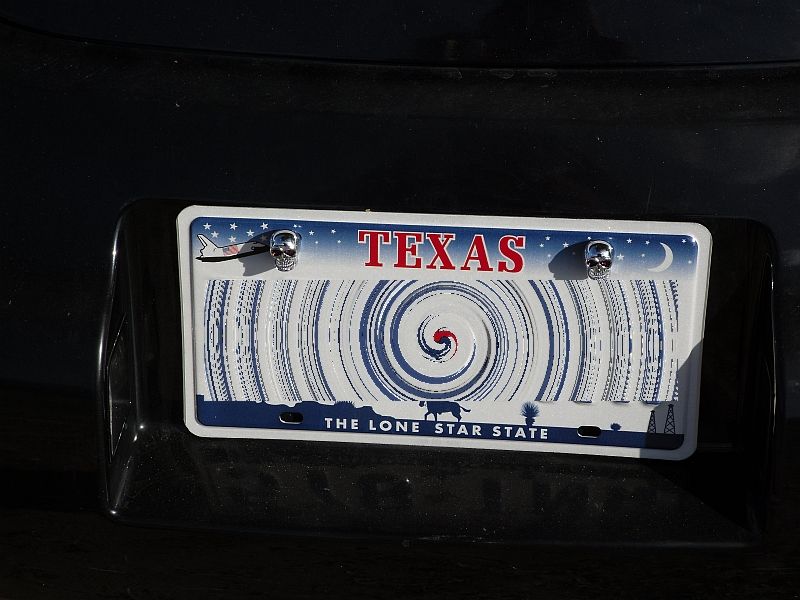 Texas license plate with skull bolt covers and a hurricane graphic