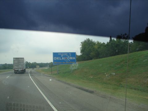 1992 Ford Taurus - Entering Oklahoma on the highway under a cloudy sky, passing a large semi-truck.