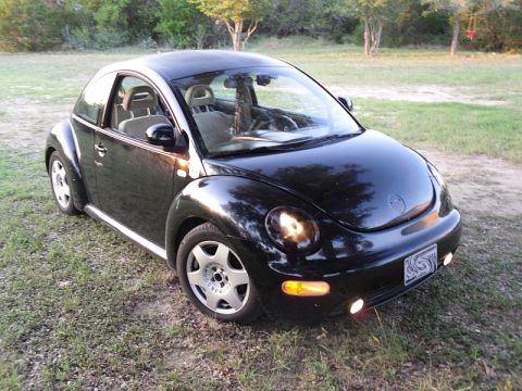 1999 Volkswagen Beetle - 1999 Volkswagen Beetle parked outdoors on a grassy area.