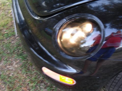 1999 Volkswagen Beetle - Close-up of a 1999 Volkswagen Beetle's front corner, showing the headlight and turn signal.