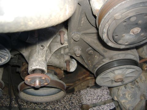 1989 Ford Bronco - Bad water pump on left, ready to move pump bracket on right. By the way, that bolt on the pump bracket that is about to come off...that goe…