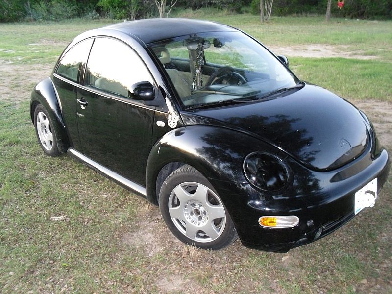 Black 1999 Volkswagen Beetle parked on grass