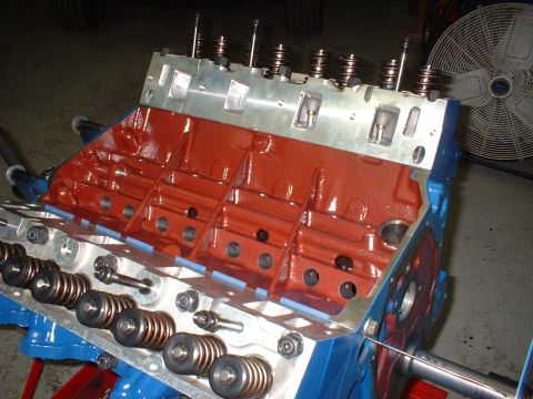 1968 Ford Galaxie - Close-up view of an engine block, painted red and blue, with internal components like valve springs and pushrods exposed.