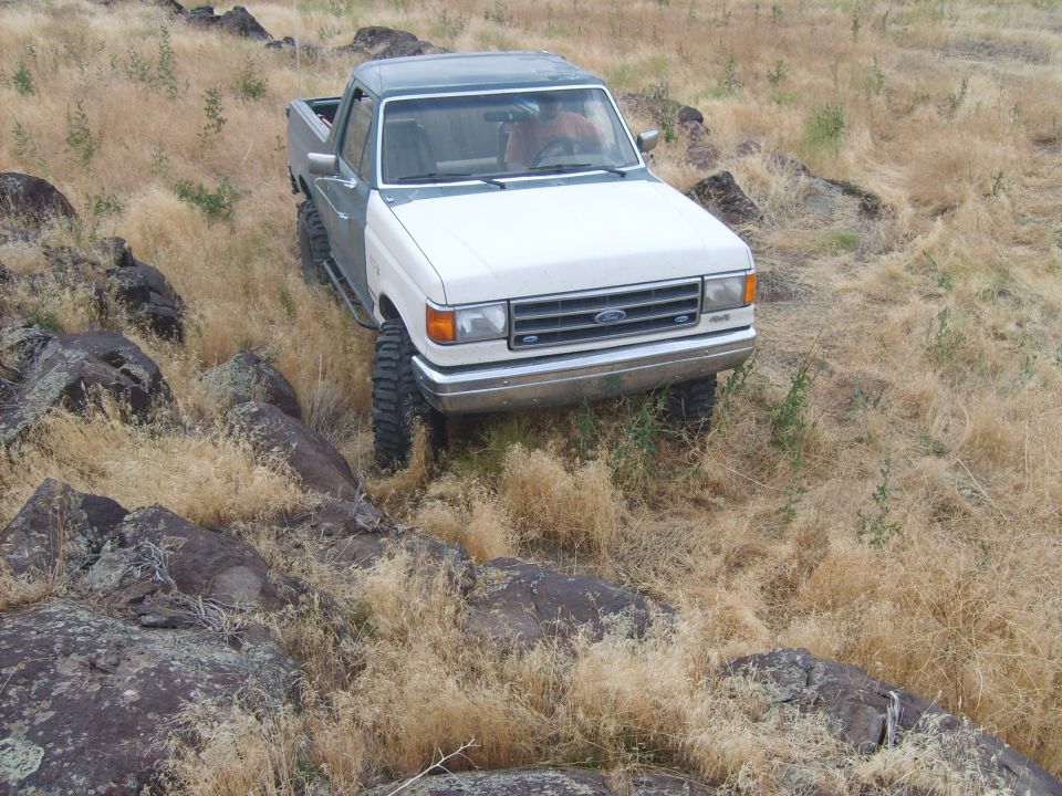 Ford F-Series pickup truck driving on rocky, dry terrain