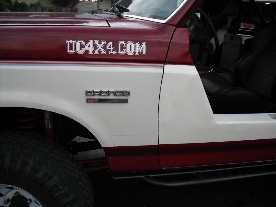 Two-tone red and white 1991 Ford Bronco with UC4X4.COM text on fender and Bronco emblem