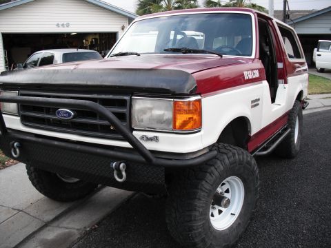 1991 Ford Bronco - This two-tone 1991 Ford Bronco features an aggressive aftermarket bumper and side steps, suggesting off-road capability.