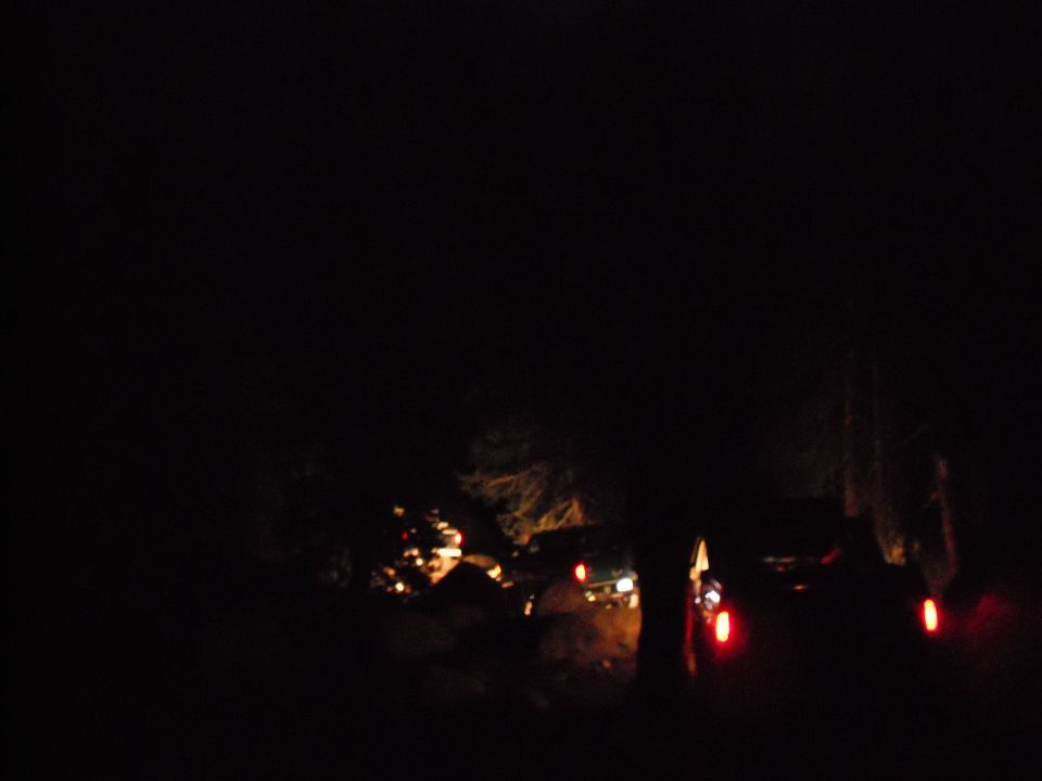 Multiple SUVs driving at night with headlights and taillights visible