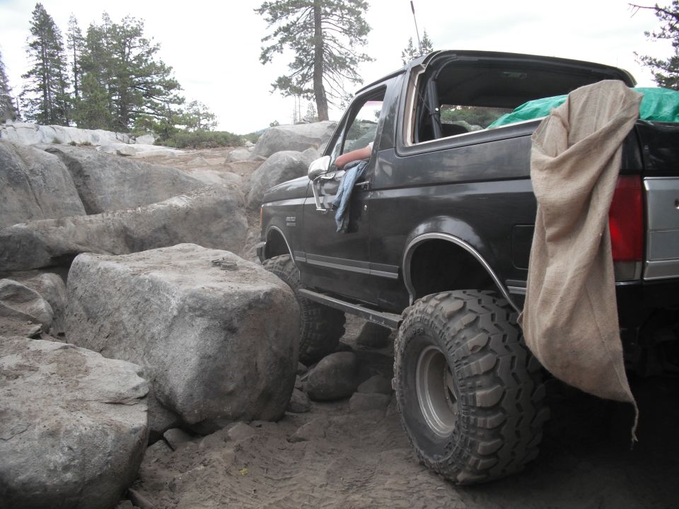 Black Ford Bronco navigating large rocks on a dirt trail
