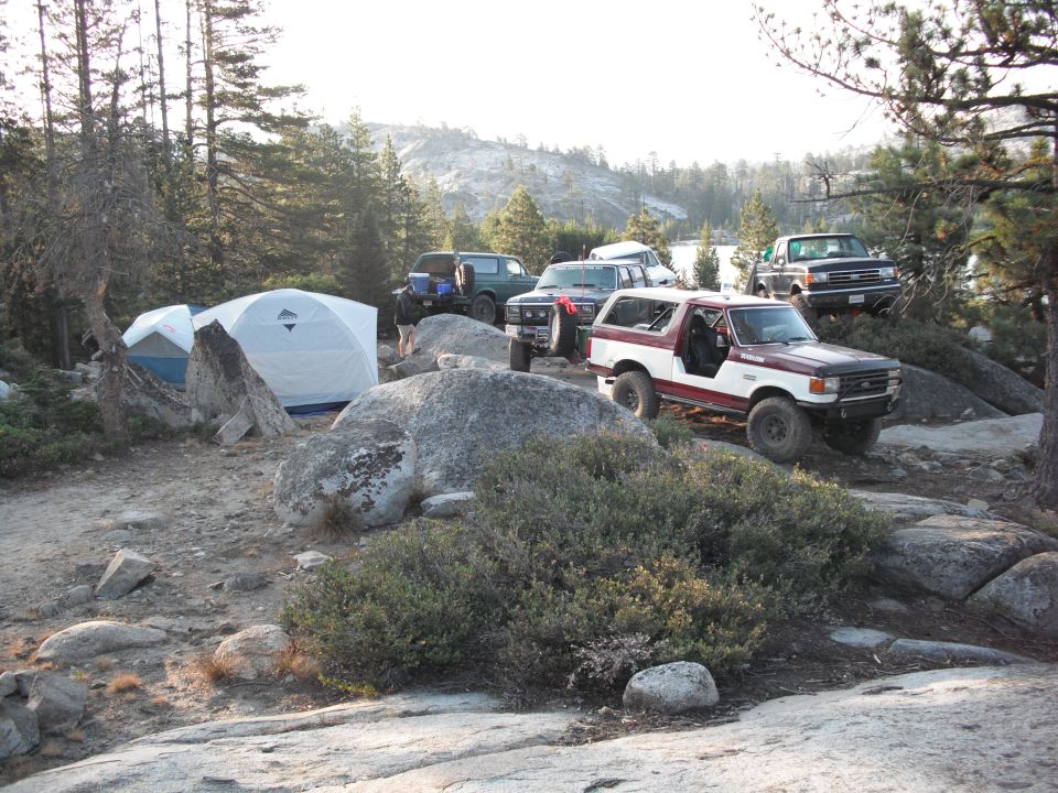 Maroon and white Ford Bronco parked on rocks, front quarter view