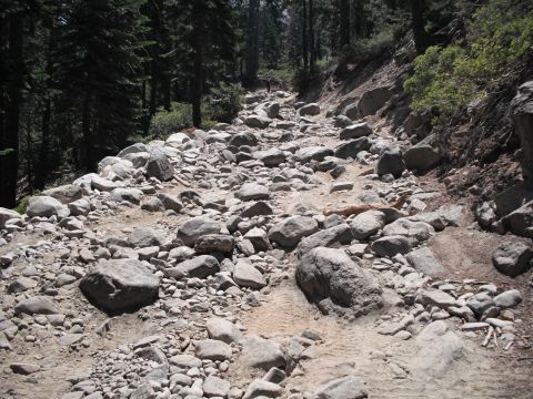 1991 Ford Bronco - A rocky mountain trail shows tire tracks winding through the boulders and trees.