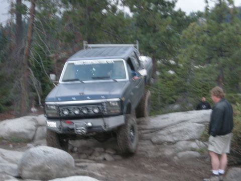 1991 Ford Bronco - This Ford F-Series truck, likely from the early 1980s, is shown off-roading on a challenging rocky path.