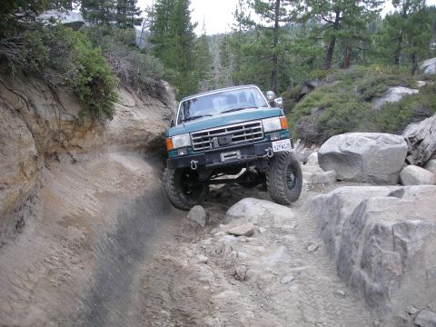 1991 Ford Bronco - This 1991 Ford Bronco is tackling a challenging rocky trail in a wooded, mountainous area.