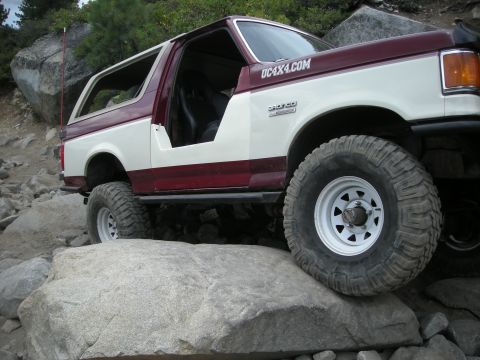 1991 Ford Bronco - This two-tone Ford Bronco is tackling a rocky trail, its off-road capabilities.