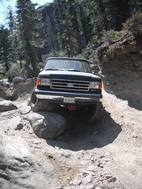 1991 Ford Bronco - This 1991 Ford Bronco is shown tackling a challenging off-road path with large rocks and steep inclines.