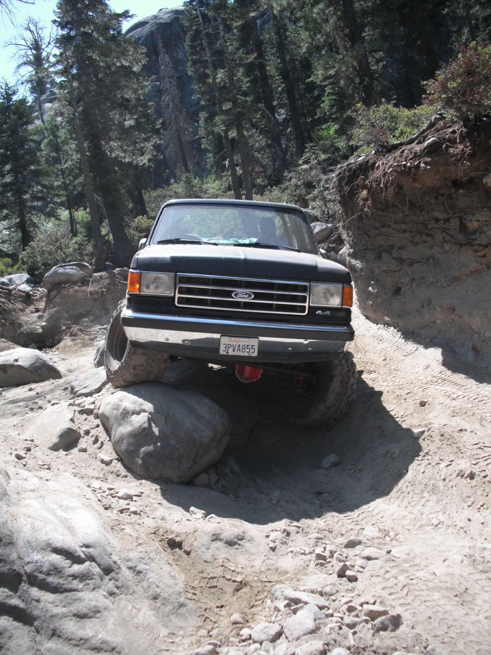 Black 1991 Ford Bronco navigating a boulder-strewn trail