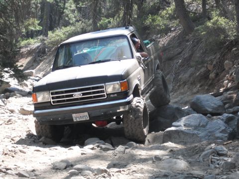 1991 Ford Bronco - This 1991 Ford Bronco is shown tackling a challenging off-road course with large rocks.