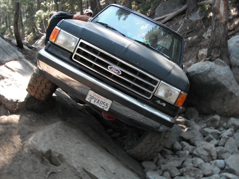 Black Ford Bronco navigating rocky terrain, front 3/4 view