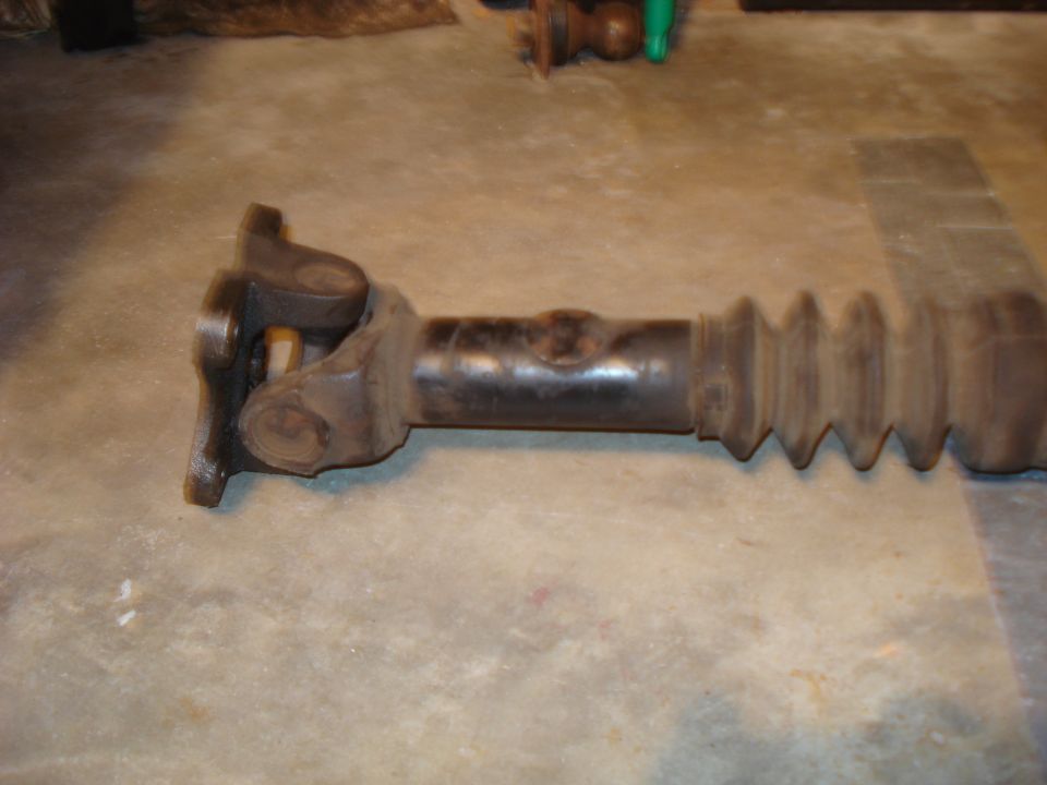 Driveshaft with U-joints and rubber boot on concrete floor