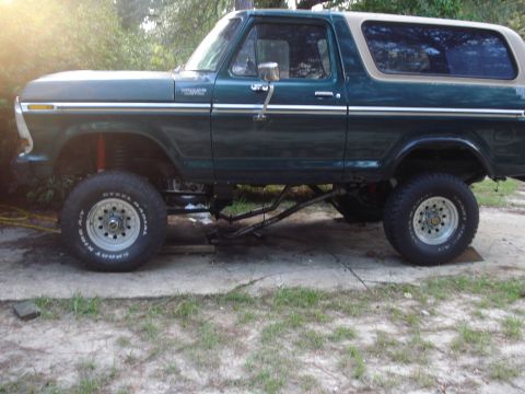 1978 Ford Bronco - Side view of a lifted 1978 Ford Bronco with a two-tone green and tan exterior.