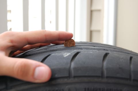 2002 BMW M3 - Tire tread depth is checked using a penny. The SuperMotors.net logo is visible in the lower right corner.
