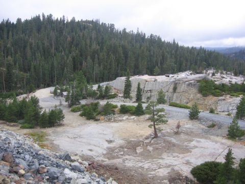 1989 Ford Bronco - A wide view of a quarry site with trees and parked vehicles on the upper level.