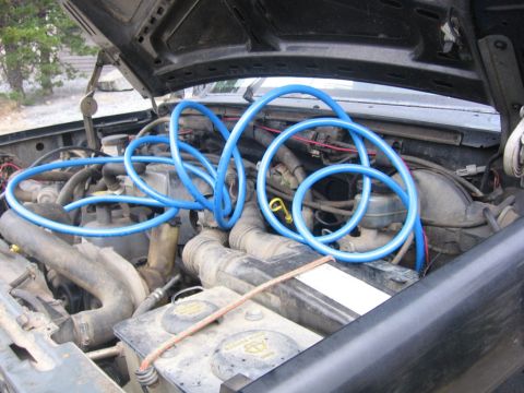 1989 Ford Bronco - Engine bay detail with blue hoses obscuring some components. Year is uncertain.