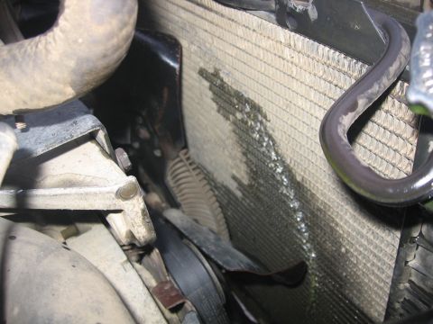 1989 Ford Bronco - Close-up of a vehicle's radiator and fan assembly, showing signs of a coolant leak.