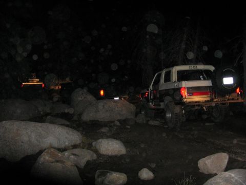 1989 Ford Bronco - A 1989 Ford Bronco navigates a rocky trail at night, with another vehicle visible in the background.