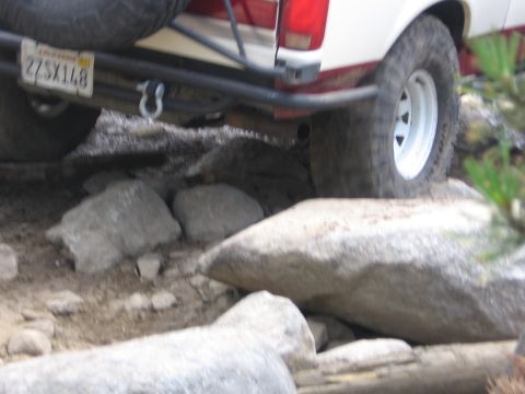 1989 Ford Bronco - This Ford Bronco navigates a rocky trail, its rear end angled over boulders.