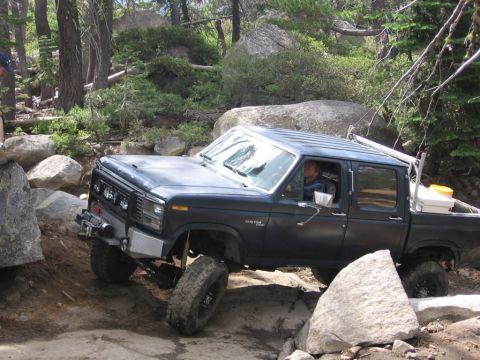 1989 Ford Bronco - This 1980s pickup truck navigates a rocky trail in a wooded area.