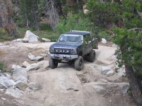 1989 Ford Bronco - This pickup truck, modified for off-road use, navigates a rocky trail.