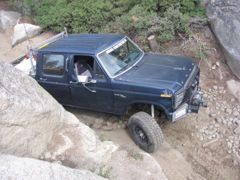 1989 Ford Bronco - This pickup truck, likely from the early 1980s, is shown off-roading on a challenging rocky path.